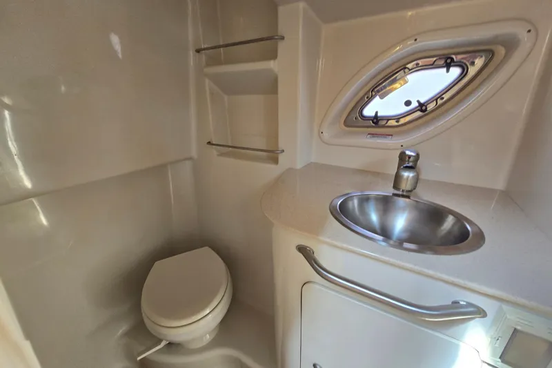 Slide: The Image of 2010 Sea Ray Sundancer 330 bathroom with toilet, sink, and porthole window. - 21