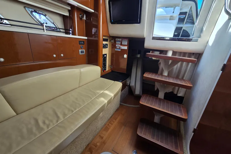 Slide: The Image of Interior of 2010 Sea Ray Sundancer 330 yacht with beige seating and wooden stairs. - 23