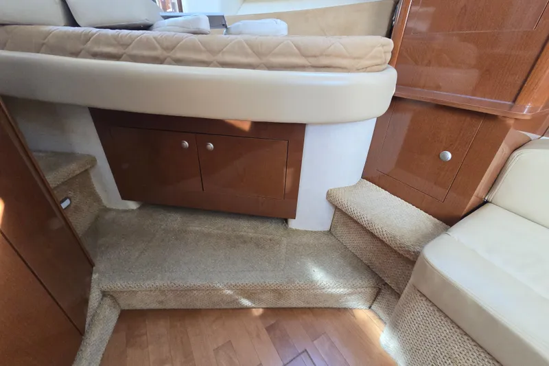 Slide: The Image of Interior of 2010 Sea Ray Sundancer 330, featuring cozy seating and wooden cabinetry. - 24