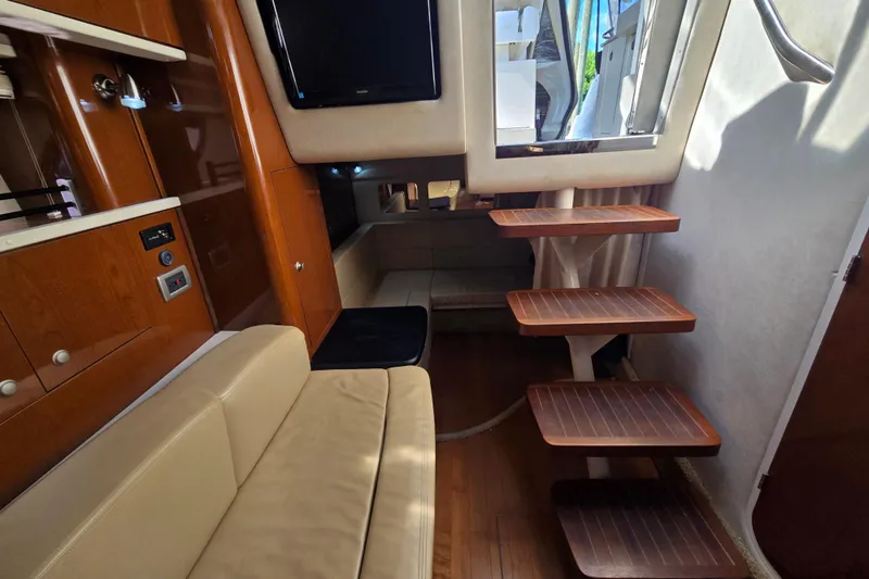 Slide: The Image of Interior of 2010 Sea Ray Sundancer 330 yacht with wooden steps and beige seating. - 27