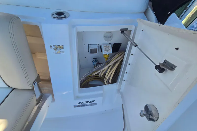 Slide: The Image of 2010 Sea Ray Sundancer 330 power compartment with cables and warning label. - 29