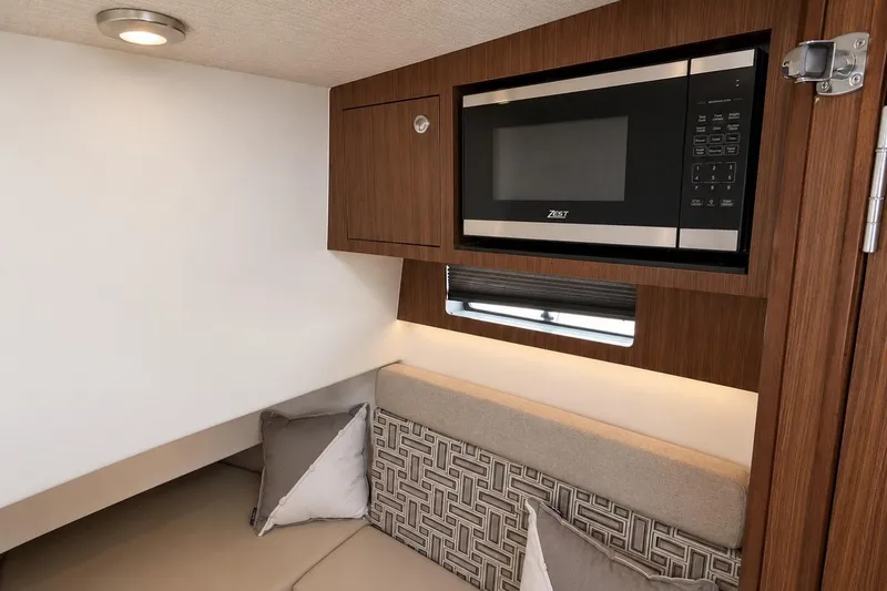 Slide: The Image of Interior of 2022 Pursuit S 358 Sport boat with microwave and seating area. - 11