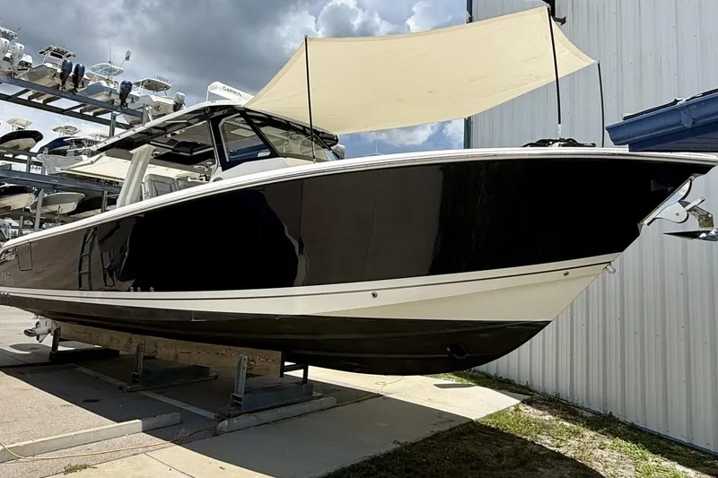 Slide: The Image of 2022 Pursuit S 358 Sport boat on display, sleek black hull, outdoor setting. - 15