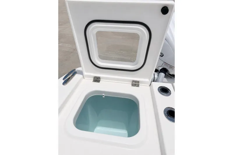 Slide: The Image of Open storage compartment on 2022 Pursuit S 358 Sport boat, featuring a hinged lid and gasket seal. - 20