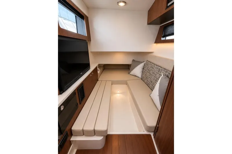 Slide: The Image of 2022 Pursuit S 358 Sport cabin interior with seating, cushions, and a TV. - 9