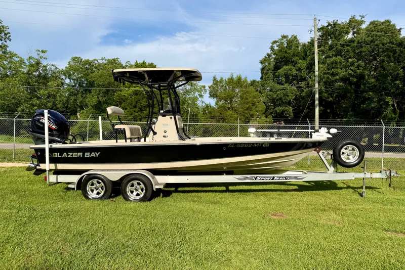 The Image of 2015 Blazer Bay 2200 Fisherman boat on trailer, parked on grass. - 1