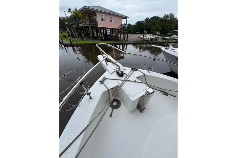 Slide: The Image of Bow view of 2003 Mainship 390 Trawler docked near waterfront house. - 10