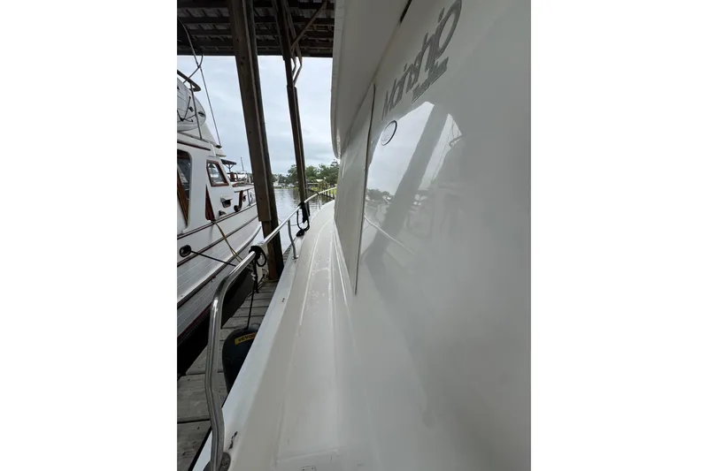 Slide: The Image of Side view of a 2003 Mainship 390 Trawler docked at a marina. - 11