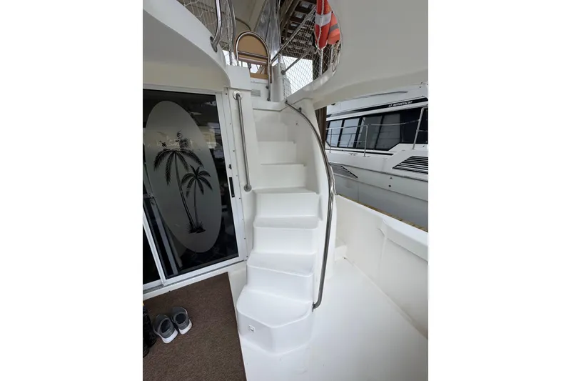 Slide: The Image of Staircase on 2003 Mainship 390 Trawler with palm tree design on glass door. - 12