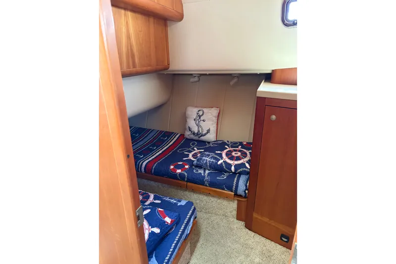 Slide: The Image of Cozy cabin interior of 2003 Mainship 390 Trawler with nautical-themed bedding. - 17