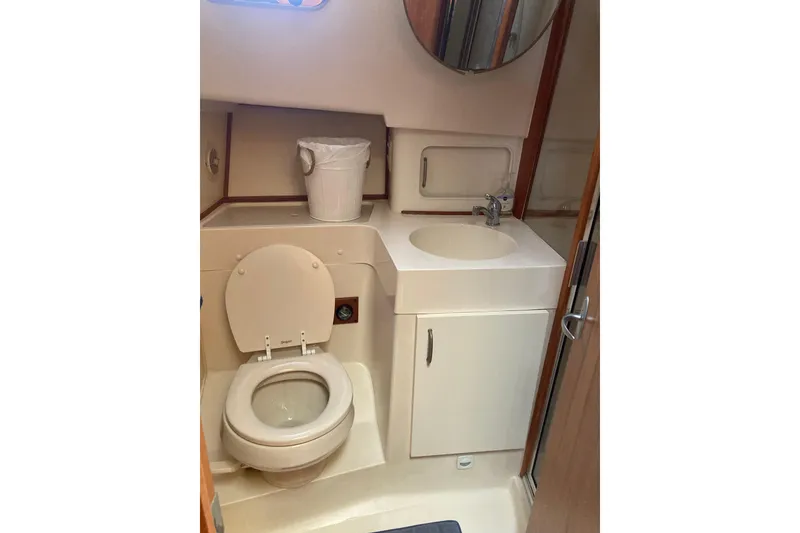 Slide: The Image of 2003 Mainship 390 Trawler bathroom with toilet, sink, and mirror. - 21