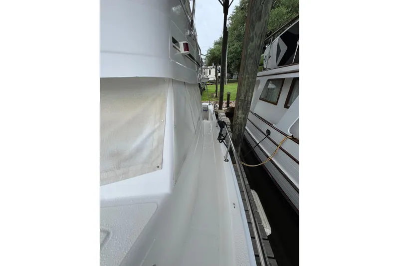 Slide: The Image of 2003 Mainship 390 Trawler docked, showcasing side deck and marina setting. - 9