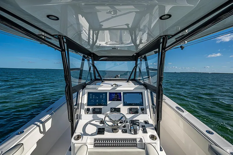 Slide: The Image of 2022 Invincible 39 Open Fisherman boat dashboard with ocean view, featuring modern navigation equipment. - 73