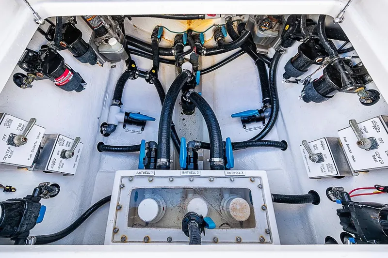 Slide: The Image of Engine compartment of 2022 Invincible 39 Open Fisherman with various valves and hoses. - 58
