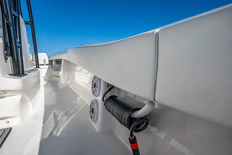 Slide: The Image of 2022 Invincible 39 Open Fisherman boat deck with speakers and hose, under clear blue sky. - 62