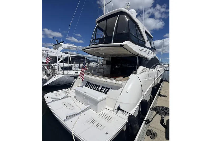 The Image of 2016 Sea Ray L590 Fly yacht docked, showcasing sleek design and spacious deck. - 0