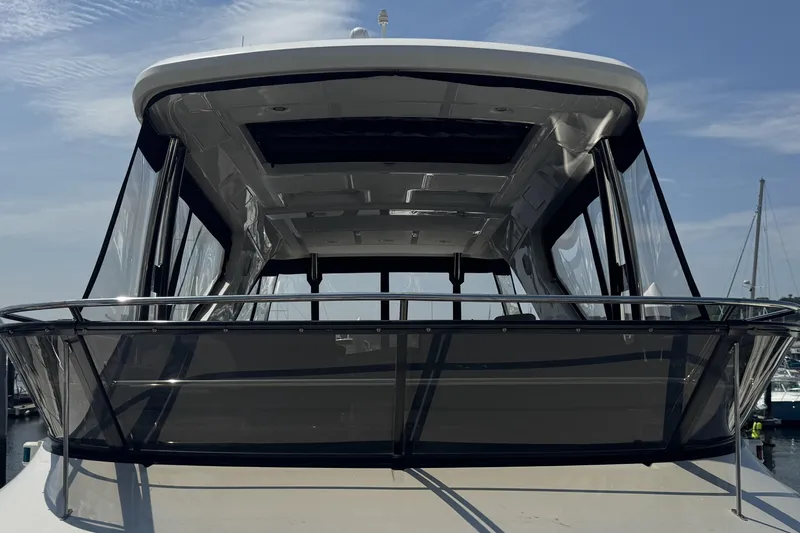Slide: The Image of 2016 Sea Ray L590 Fly yacht with sleek design, docked under clear blue sky. - 24
