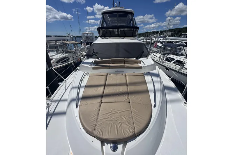 Slide: The Image of 2016 Sea Ray L590 Fly yacht with sunpad, docked under a clear blue sky. - 41