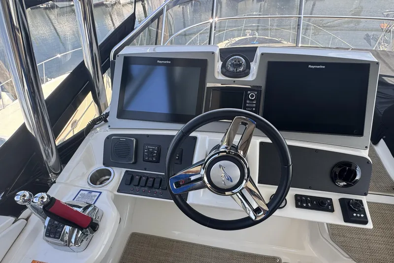 Slide: The Image of Helm of 2016 Sea Ray L590 Fly yacht with dual Raymarine displays and steering wheel. - 6
