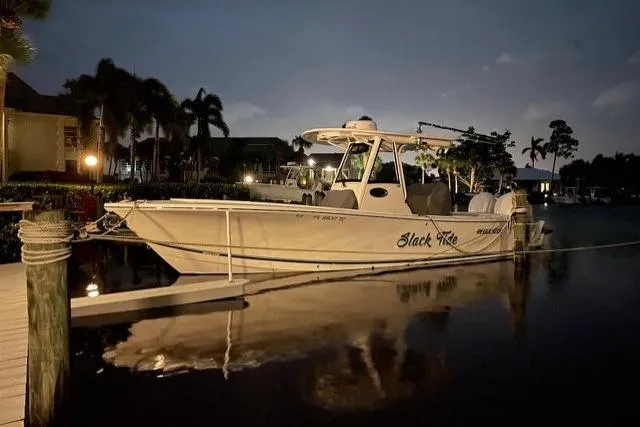Slide: The Image of 2022 Regulator 28 boat docked at night, illuminated by soft lighting. - 1