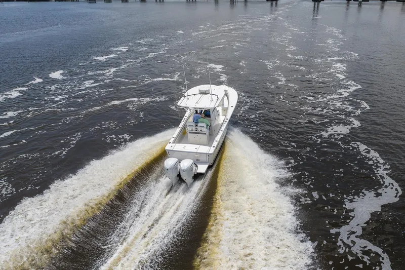 Slide: The Image of 2022 Regulator 28 boat cruising on open water, leaving a wake behind. - 8