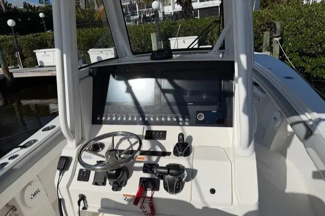 Slide: The Image of 2022 Regulator 28 boat dashboard with steering wheel and control panel. - 13