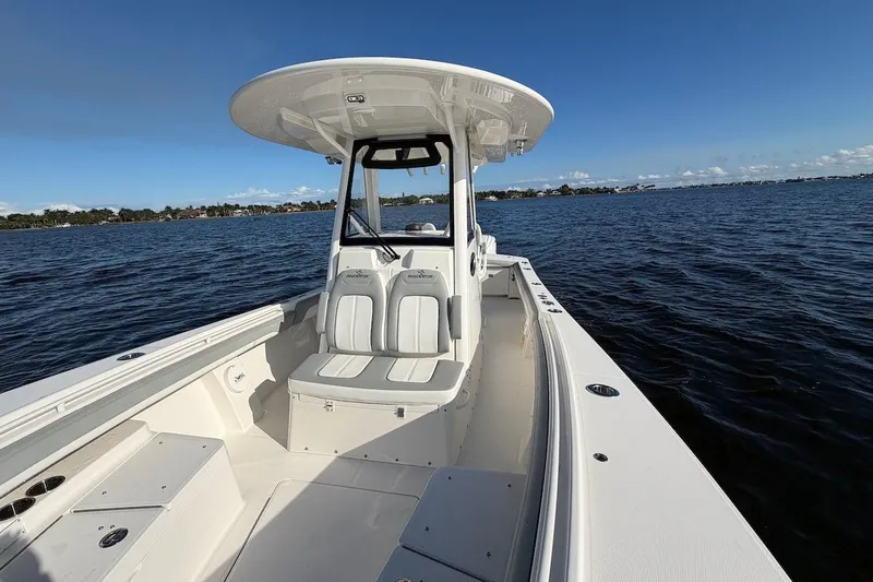 Slide: The Image of 2022 Regulator 28 boat on calm water, featuring spacious seating and sleek design. - 14