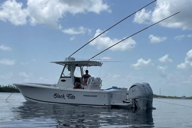 Slide: The Image of 2022 Regulator 28 boat on calm water under a partly cloudy sky. - 15