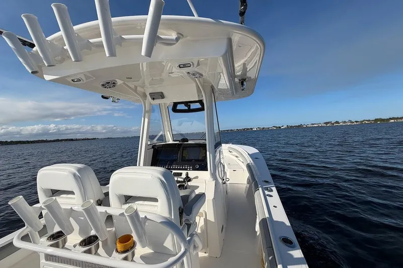Slide: The Image of 2022 Regulator 28 boat on open water, featuring a sleek console and rod holders. - 17