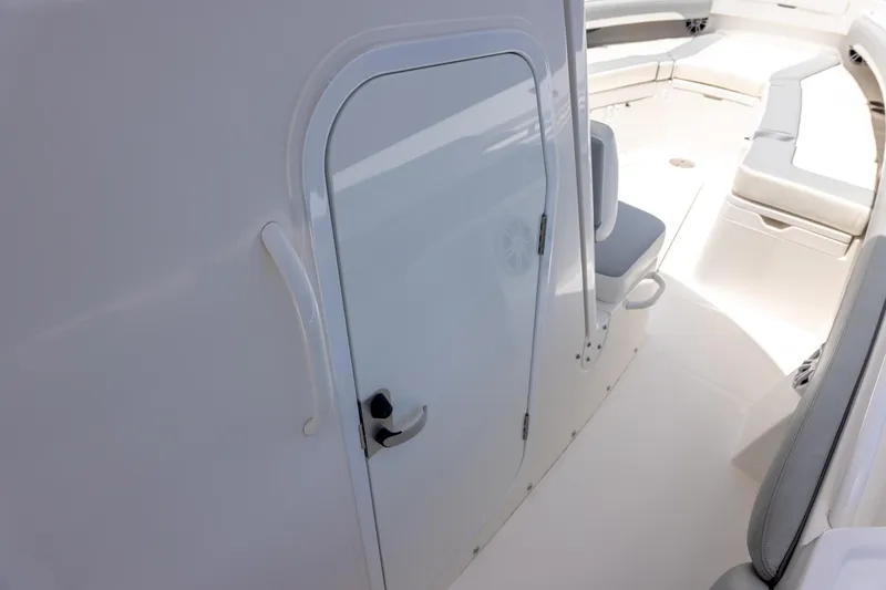 Slide: The Image of 2022 Regulator 28 boat interior with white door and seating area. - 28