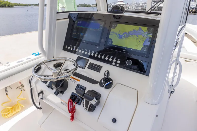 Slide: The Image of 2022 Regulator 28 boat dashboard with dual navigation screens and steering wheel. - 17