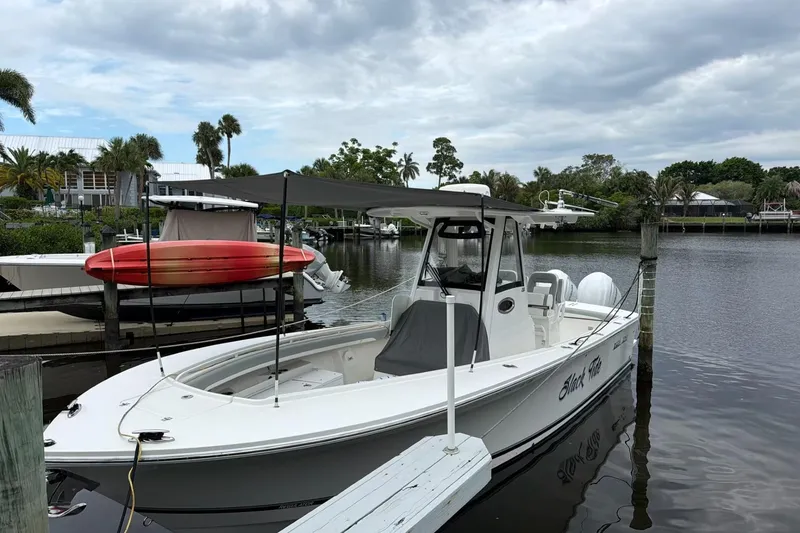 Slide: The Image of 2022 Regulator 28 boat docked in a scenic marina with overcast skies. - 3