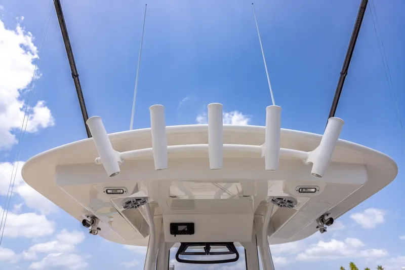 Slide: The Image of 2022 Regulator 28 boat top view with rod holders against blue sky. - 50