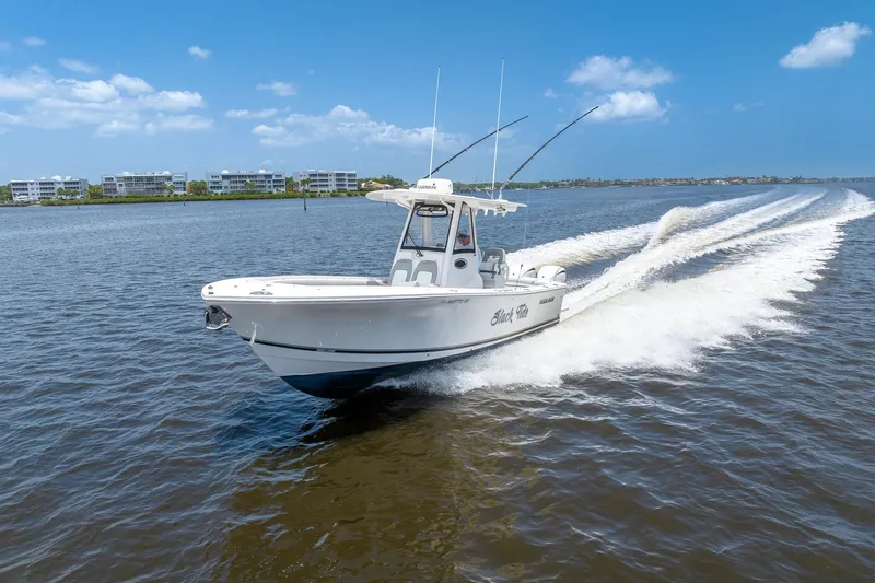 Slide: The Image of 2022 Regulator 28 boat cruising on open water under a clear blue sky. - 2