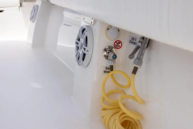 Slide: The Image of 2022 Regulator 28 boat interior with speakers, charger, and coiled hose. - 26