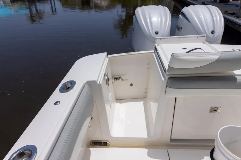 Slide: The Image of 2022 Regulator 28 boat interior with dual Yamaha engines, docked on calm water. - 47