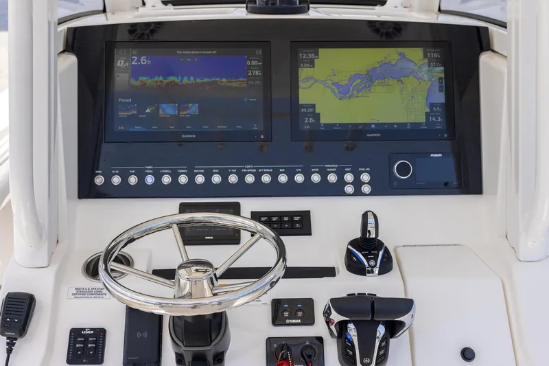 Slide: The Image of 2022 Regulator 28 boat dashboard with Garmin navigation displays and controls. - 16