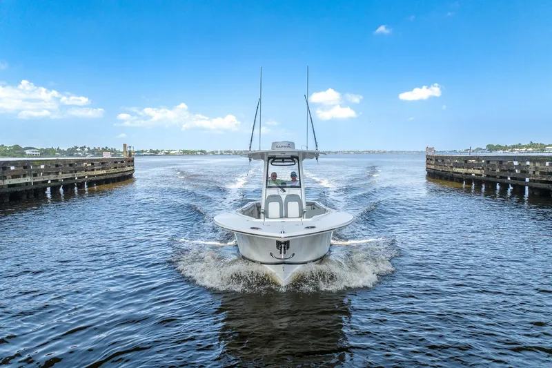 Slide: The Image of 2022 Regulator 28 boat cruising through a waterway under a clear blue sky. - 10