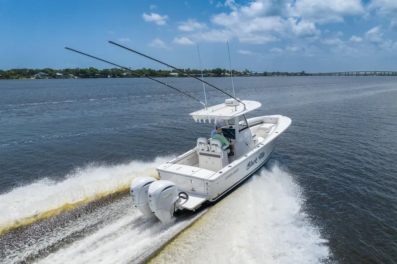 Slide: The Image of 2022 Regulator 28 boat cruising on a sunny day with dual engines. - 1