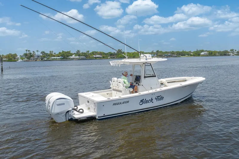 Slide: The Image of 2022 Regulator 28 boat on water with Yamaha engines, clear sky background. - 3