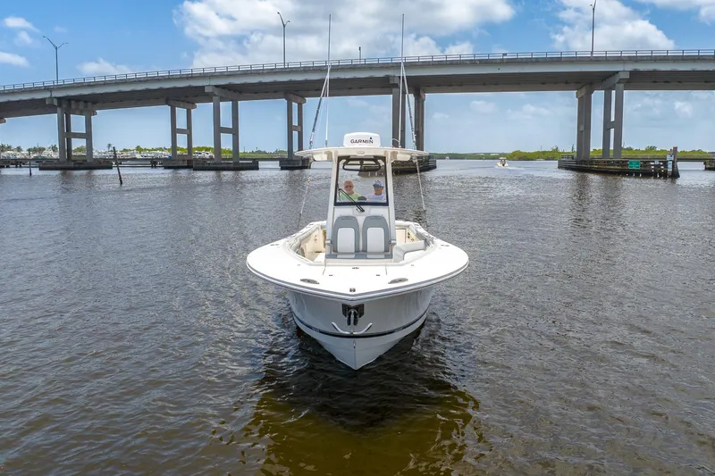 Slide: The Image of 2022 Regulator 28 boat cruising under a bridge on a sunny day. - 6