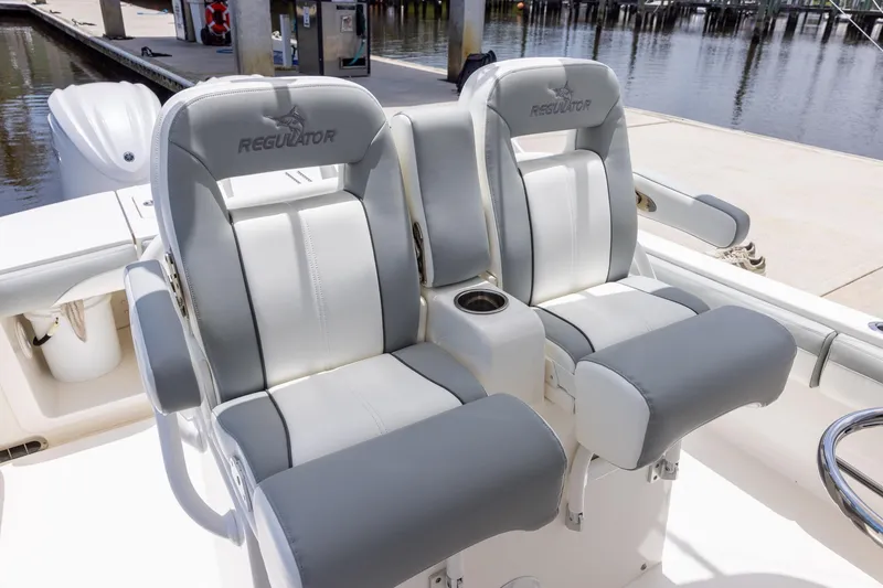 Slide: The Image of 2022 Regulator 28 boat seats with cup holders, dockside view. - 31