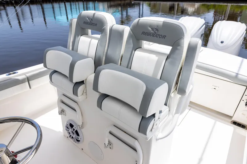 Slide: The Image of 2022 Regulator 28 boat interior with dual cushioned seats and steering wheel. - 24