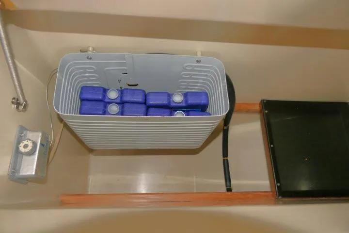 Slide: The Image of Storage compartment with blue containers in a 1988 Irwin 38-2 sailboat. - 14