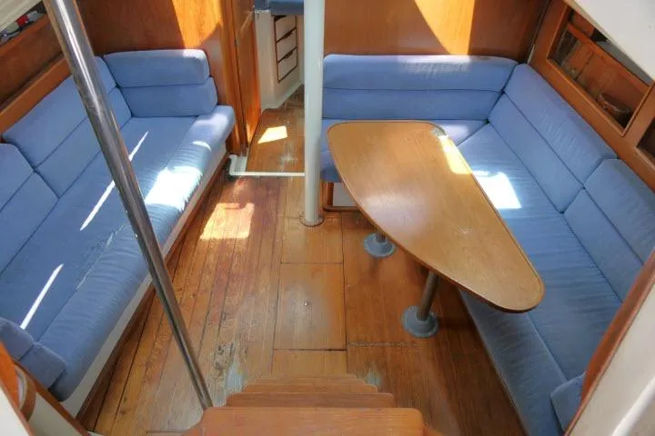 Slide: The Image of Interior of 1988 Irwin 38-2 sailboat with blue seating and wooden table. - 2