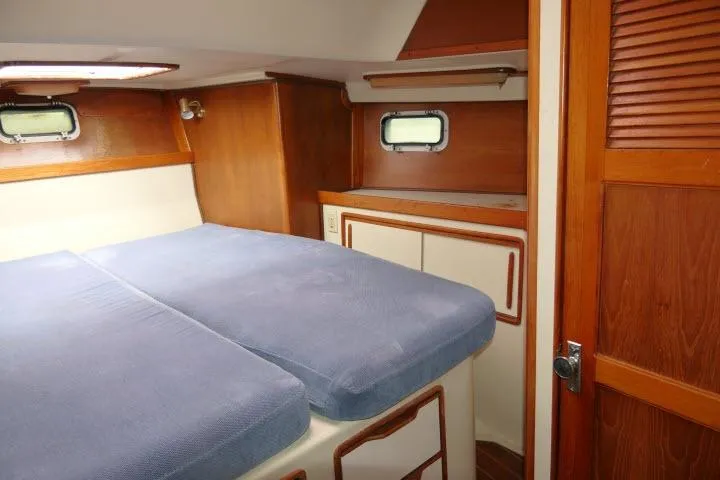 Slide: The Image of Cozy cabin interior of 1988 Irwin 38-2 sailboat with wooden accents and blue bedding. - 26