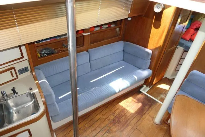Slide: The Image of Interior of 1988 Irwin 38-2 sailboat with blue sofa and wooden flooring. - 3