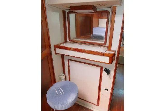 Slide: The Image of 1988 Irwin 38-2 yacht interior with vanity mirror and cushioned stool. - 30