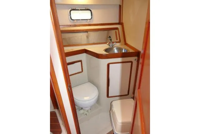 Slide: The Image of 1988 Irwin 38-2 yacht bathroom with sink, toilet, and wooden accents. - 32