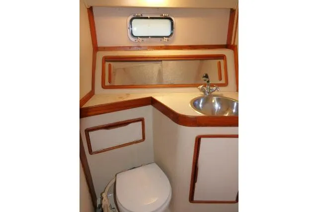 Slide: The Image of 1988 Irwin 38-2 yacht bathroom with sink, toilet, and porthole window. - 33